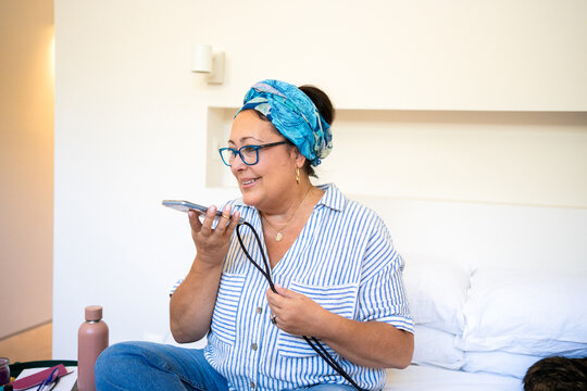A Woman Is sending audio message On Her Mobile At Bedroom 