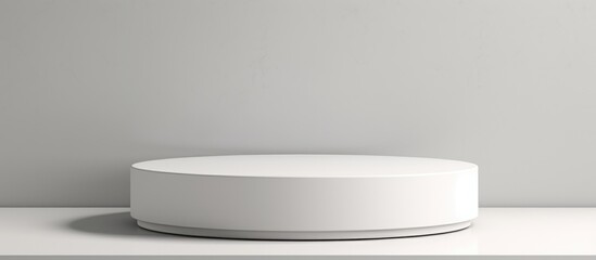 A white round object is positioned on top of a counter in a clean and modern display. The object appears to be a showcase podium or product stand, conveying a sense of simplicity and minimalism.