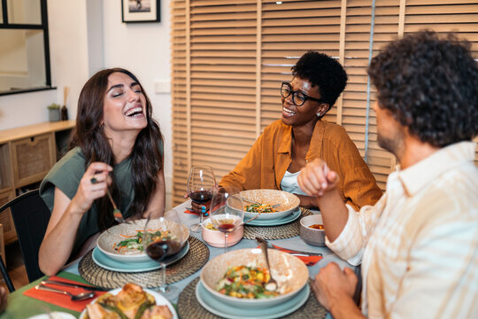 Diverse Friends Having Dinner at home While chatting