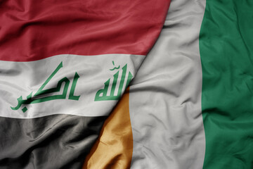big waving national colorful flag of cote divoire and national flag of iraq.