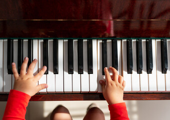 crop of little girl hand learning to play the piano