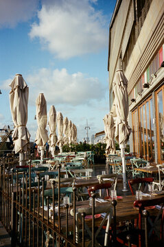 Tel Aviv Seaside Restaurant. Open Sky, Wooden Tables, and Chairs.
