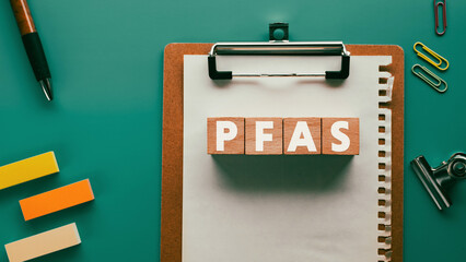 There is wood cube with the word PFAS. It is an abbreviation for Per-and Polyfluoroalkyl Substances as eye-catching image. - obrazy, fototapety, plakaty