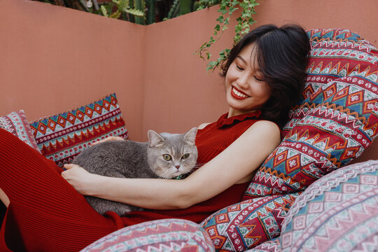 Beautiful young Asian woman with a fluffy cat outdoor