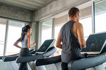 Group of Healthy Asian man and woman athlete in sportswear jogging workout exercise on treadmill at fitness gym. Wellness people do sport training cardio workout on running machine at sport club. - obrazy, fototapety, plakaty