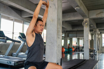 Health care motivation concept. Healthy Asian man in sportswear stretching body and warm up...