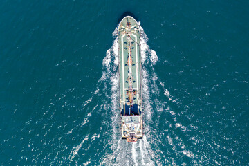 Aerial top view of cargo maritime ship with contrail in the ocean ship carrying container and...