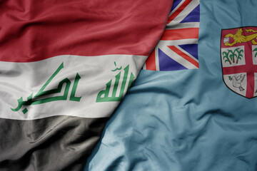 big waving national colorful flag of Fiji and national flag of iraq.