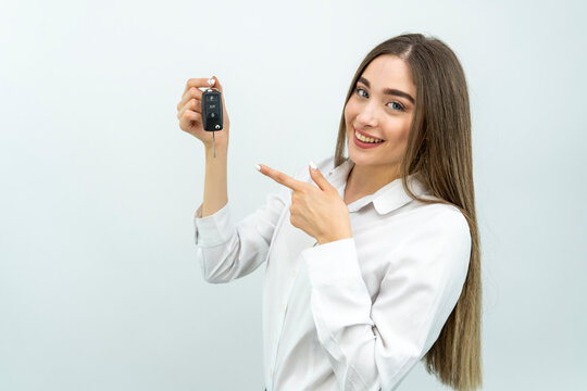 Young smiling fun happy caucasian woman 20s in holding in hand car key fob keyless system isolated on white color background studio. People lifestyle concept