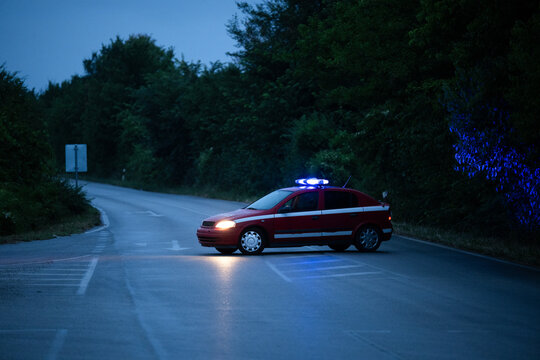 Road closed by police car after accident during rainy night