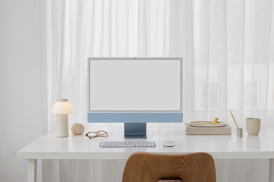 Mockup of a modern blue computer with white screen in a stylish office