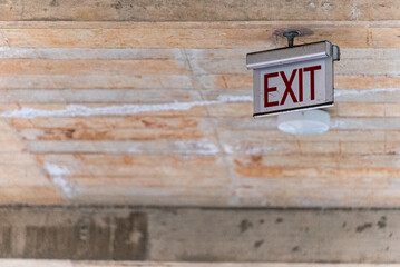 An old exit sign seen mounted to the ceiling