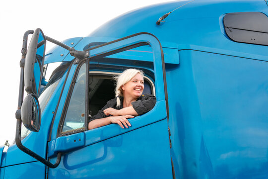 female truck driver preens ar side mirror