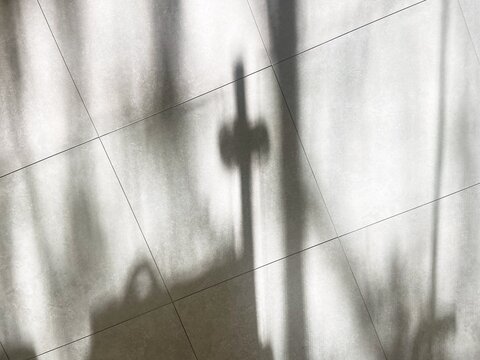 Grainy shadow cross on tiled floor