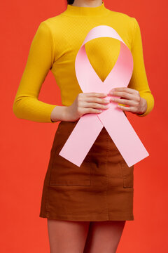 Woman's hand holding pink ribbon