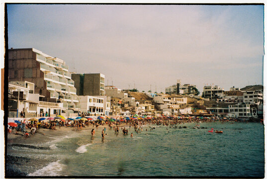Coastal Village Bustle: Lima, Peru Crowded Beach and Seaside Buildings
