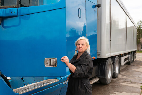 female truck driver preens ar side mirror
