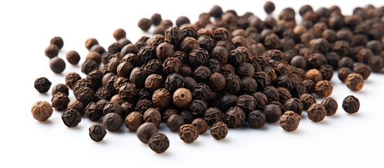 A mound of pungent black pepper seeds is piled on a clean, white surface. The pepper grains are dark in color and form a textured heap.