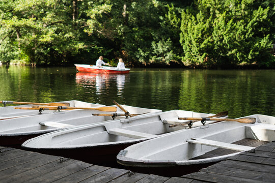 Fototapeta Rowboats docked at wooden pier on the lake