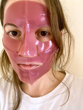 Young woman in pink hydrogel mask