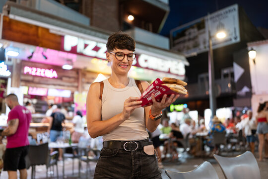 Woman holding takeaway pizza slices.