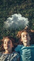Siblings lying on the grass looking at clouds close-up on faces full of imagination