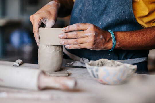 Close-up view of male Potter hands modeling a vase of clay
