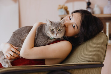 Beautiful young Asian woman with a fluffy cat 