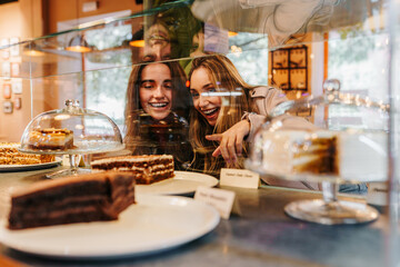 good friends choosing a slice of cake from the cafeteria counter