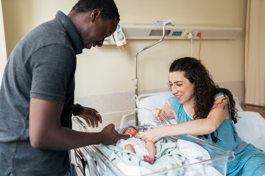 Multicultural couple in the hospital room after giving birth - Powered by Adobe