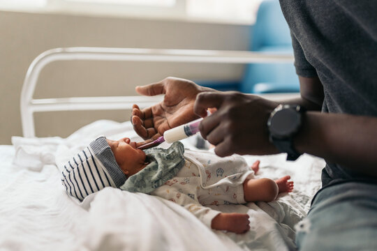 Feeding a baby with formula milk in a hospital room