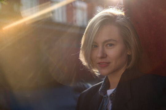 Elegant model looking at the camera with sunray effect on sunny day