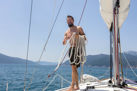 Man with skein of rope on the deck