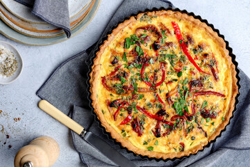 Gourmet chicken quiche with capsicum captured in an overhead landscape shot on a light table...