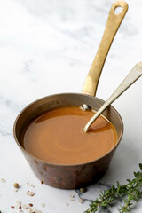 French brown sauce served in a small copper pot with a spoon