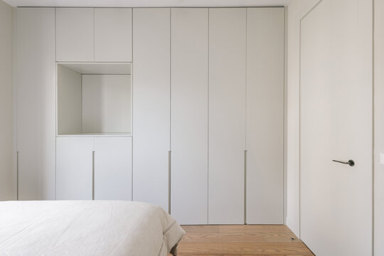 Minimalist bedroom with a wall full of closets