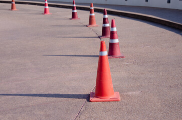Orange and red with white stripe traffic cones on road