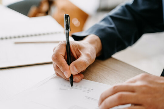 A man's hand signs the document
