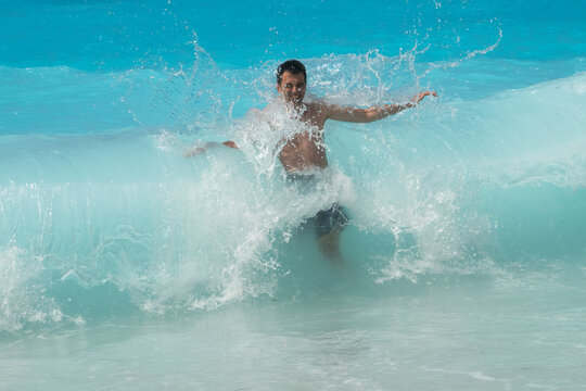 Man in a turquoise sea wave splash
