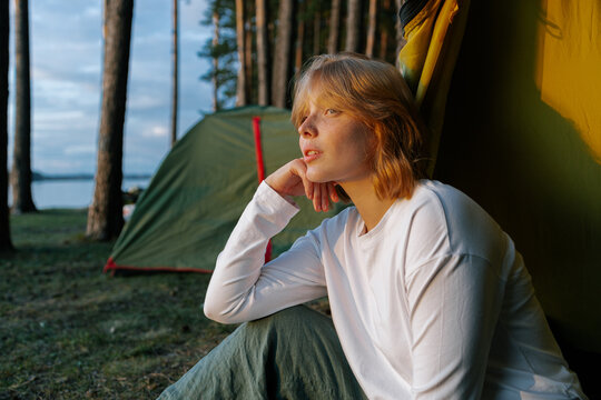 A woman is sitting near a tent