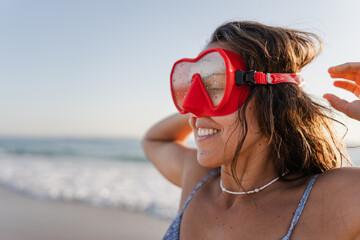 portrait of a woman with red diving goggles at the beach