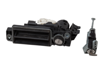 Detail of a car spare part made of black plastic and metal - keyhole lock with key for opening the trunk separately, isolated on a white background. Repair in a car workshop, equipment for sale.