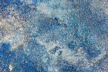 Blue painted asphalt texture. Rough, grainy surface. Urban background.