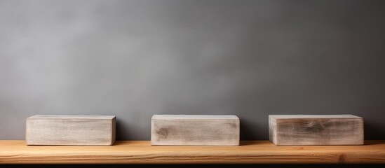 A row of white blocks is neatly arranged on a wooden shelf with an empty top, against a gray background. The blocks are sitting upright, creating a clean and organized display.
