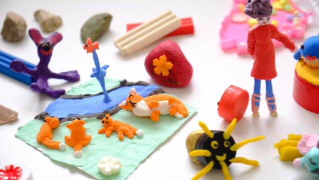 Child making crafts using natural dry plants, flowers, grass, leaves and use plastic corks, stones,  plasticine, beads and paper. Back to school. Making diorama. Ideas for children's art