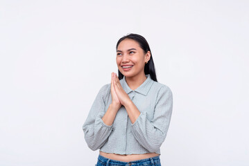 A gracious young Asian woman with a thankful expression, hands together, isolated on a white...