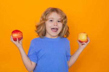 Healthy fruits for kids. Kid with apple in studio. Studio portrait of cute child hold apple isolated on yellow background.