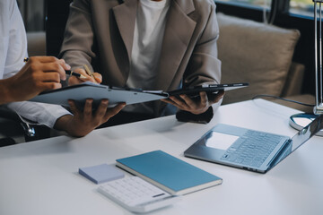 Business team working with new startup project plan and discussion information for financial strategy with laptop and digital tablet in a modern business lounge.