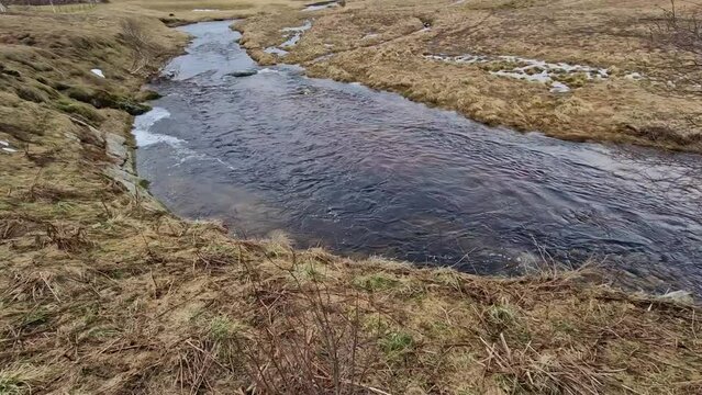 bog is full of water in spring after the snow melts. a layer of black peat soil can be seen flowing over the edge, which is used in the cosmetic industry and medicine. it used to heat up, glacial