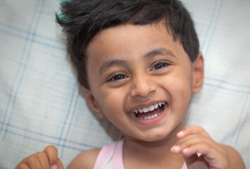 Smiling young boy on striped background
